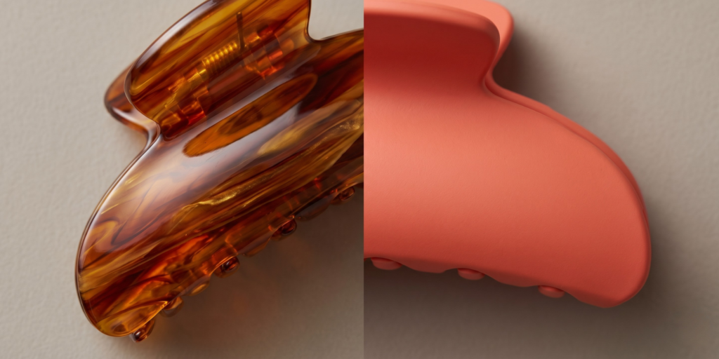 Close-up of acetate claw clip showing translucent marbled pattern alongside plastic claw clip showing solid opaque surface finish