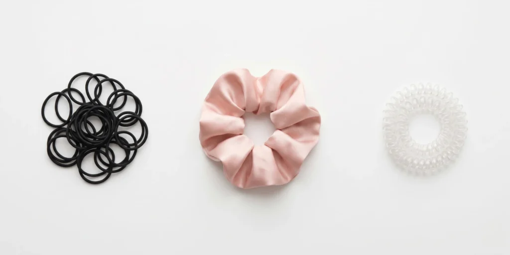 Spiral coil hair tie and satin scrunchie displayed as lower-damage alternatives to rubber elastic band for different use cases