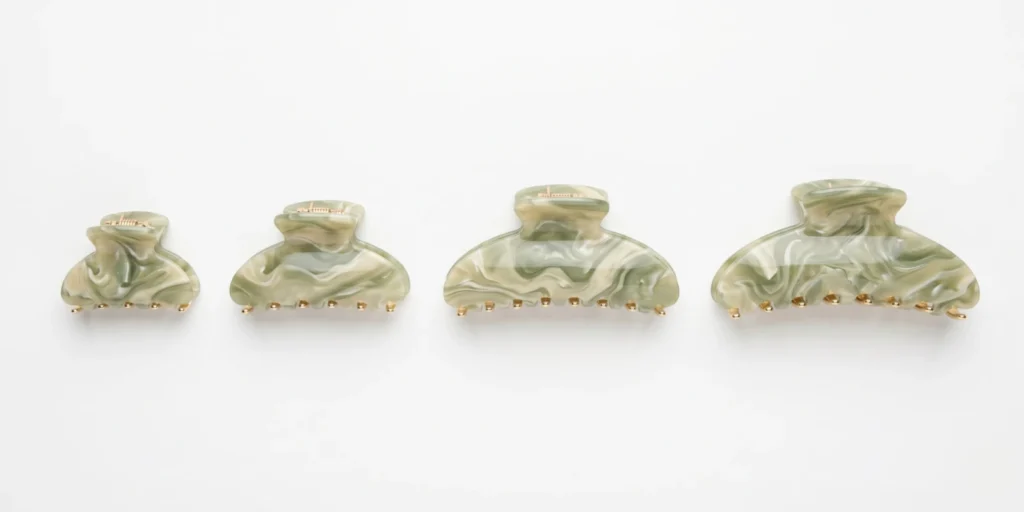 Size-assorted claw clip range in matching acetate colourway displayed for retail range planning reference