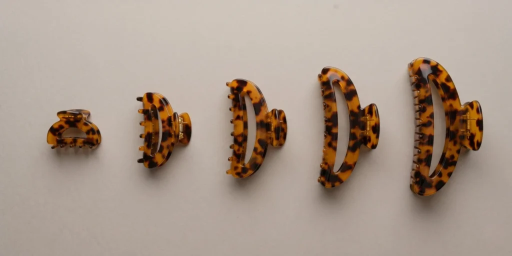 Claw clips in five size categories labelled mini through oversized displayed with spacing on a neutral background
