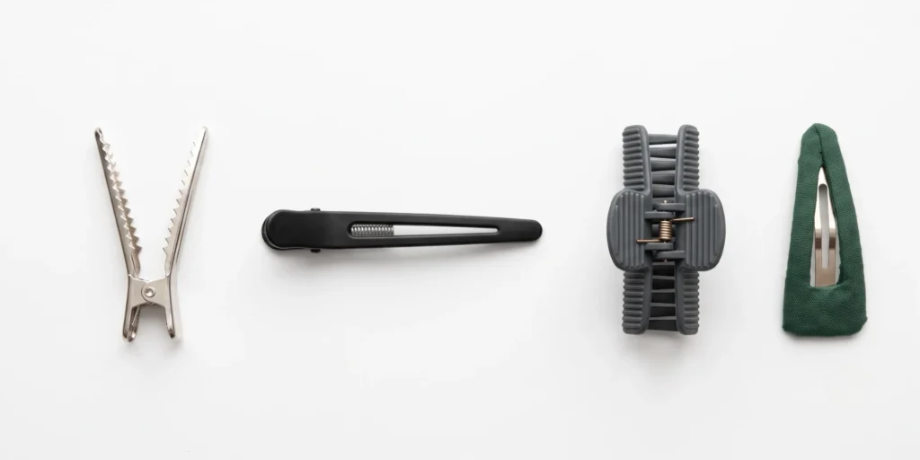 Four alligator clip variants including metal crocodile clip, duckbill clip, plastic sectioning clip and decorative snap clip in a row