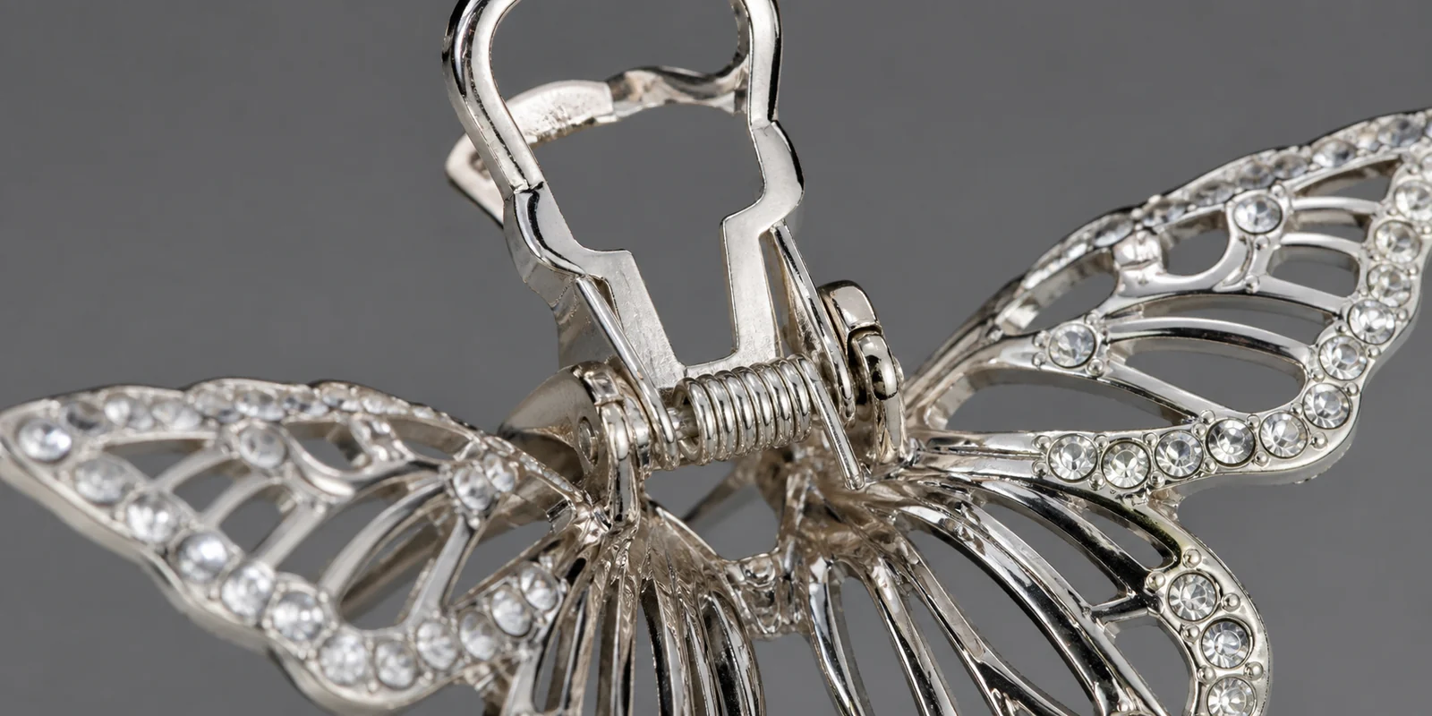 Close-up of a metal butterfly clip spring hinge mechanism showing reinforced construction
