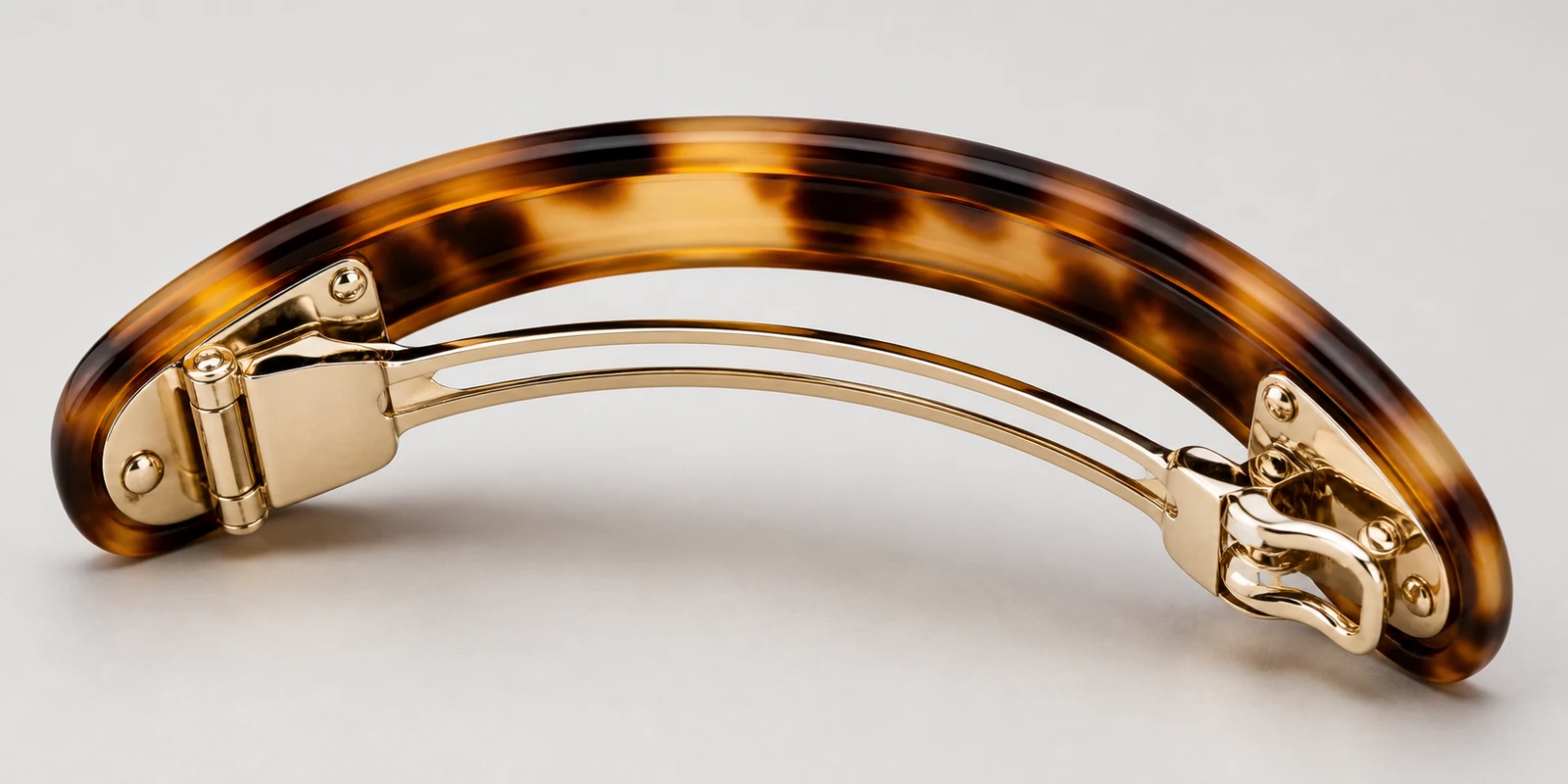 Close-up of a volume barrette metal tension bar and hinged clasp mechanism