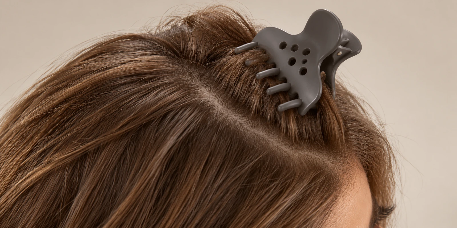 Volumizing root clip holding a small section of hair lifted at the crown